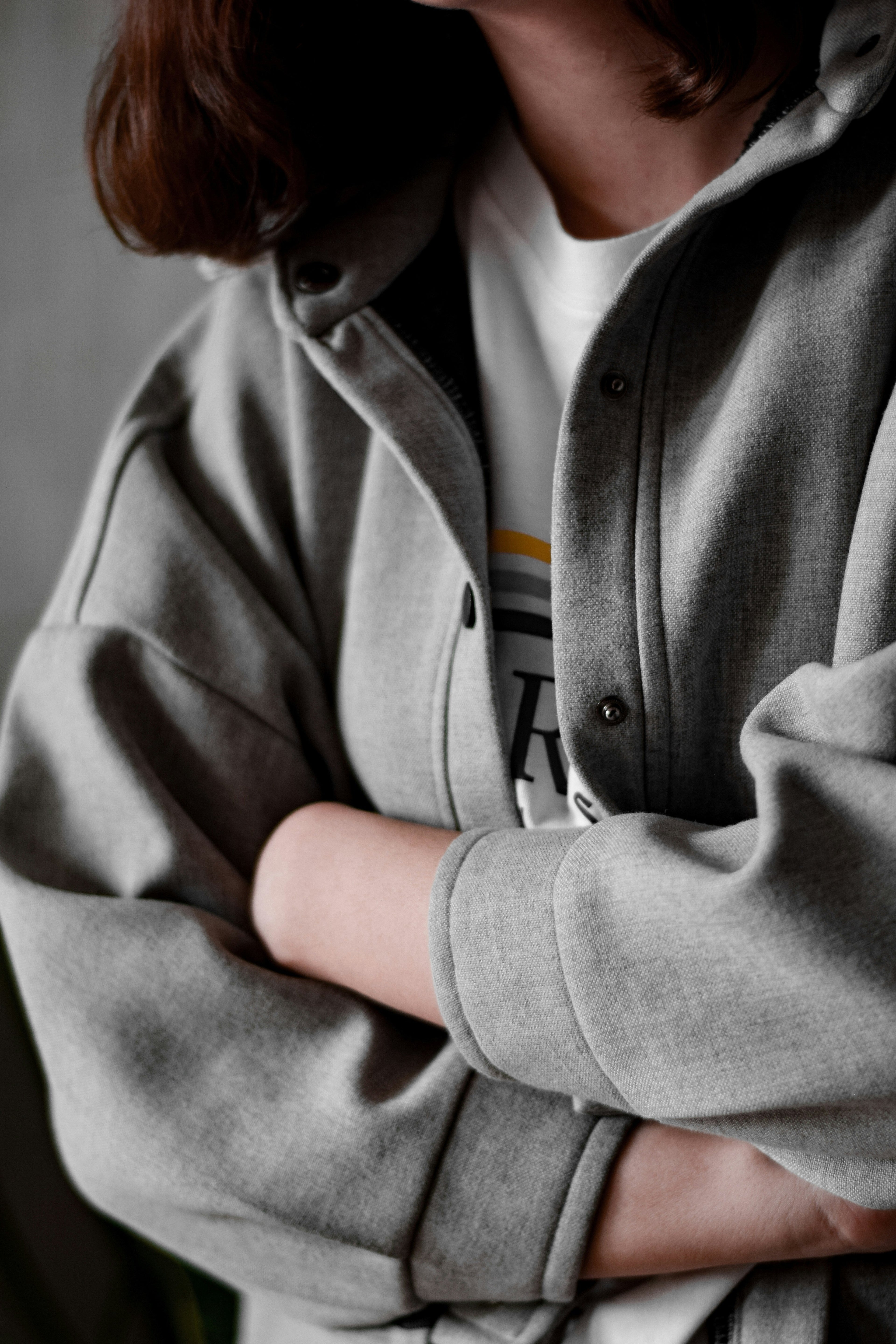 Person wearing a gray jacket with a blurred background